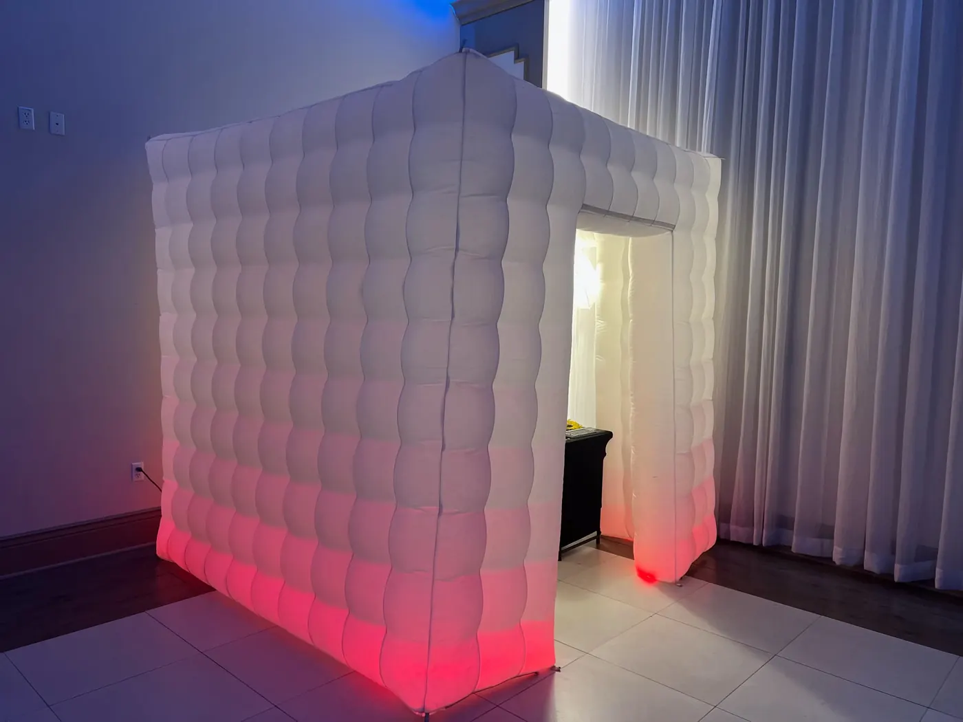 White inflatable photo booth enclosure lit in pink